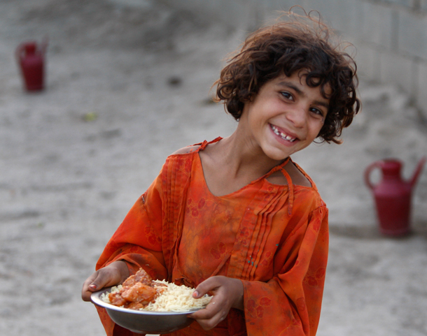 A child reacts after receiving food distributed on the occasion of Ramadan at a refugee camp, at a refugee camp. Muslims across the world refrain from eating, drinking and smoking from dawn to dusk during Ramadan. (AP)