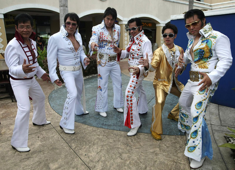 Elvis Presley impersonators dressed in costumes pose for a photograph before the start of a singing contest to mark Presley's 33rd death anniversary in Manila. (EPA)