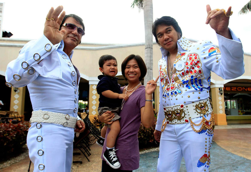 Filipino Elvis Presley impersonators pose with a woman and her child  during  a contest in Pasay City, south of Manila, Philippines. (EPA)