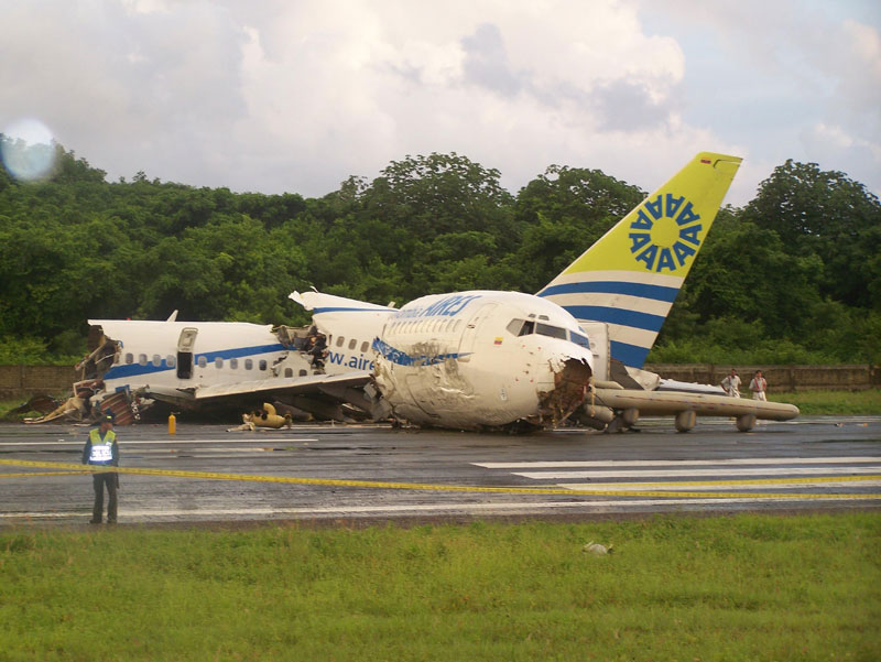 A police officer stands by a crashed plane sitting on the runaway at the airport on San Andres island in Colombia. (AP)