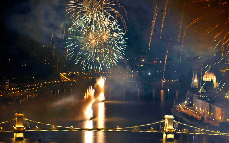 Fireworks fired from barges on the river Danube explode over the illuminated Chain Bridge and Hungarian Parliament, right, in Budapest, Hungary, marking the 1010th anniversary of the foundation of the Hungarian State by King St. Stephen. (AP)