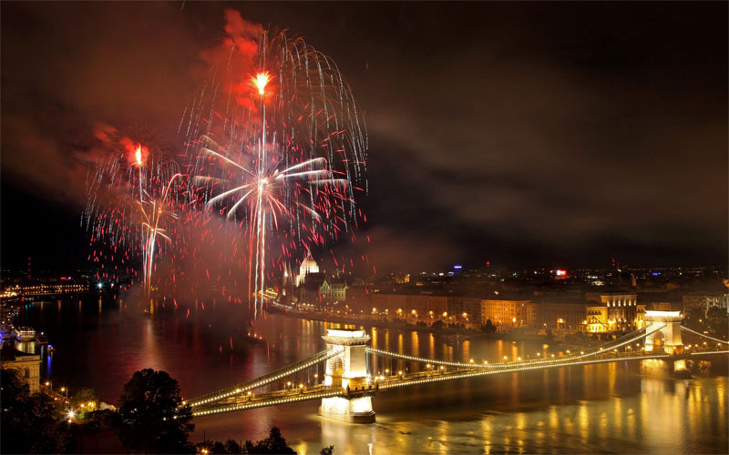 Backdropped by a view of the dome of the Hungarian Parliament, right,  fireworks fired from barges on the river Danube explode in Budapest, Hungary. (AP)