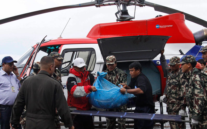 Nepalese soldiers carry the remains of a plane crash victim in Katmandu, Nepal, Tuesday. (AP)