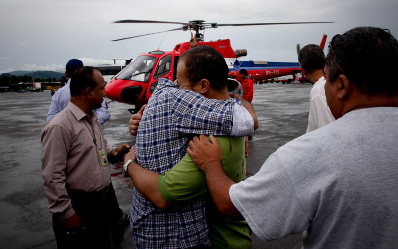 Sashi Shah (green shirt), brother of pilot Laki Shah, who died during the Agni Air plane crash, is being consoled by others as the remains of the victims arrive in Kathmandu Airport in Kathmandu, Nepal. (EPA)