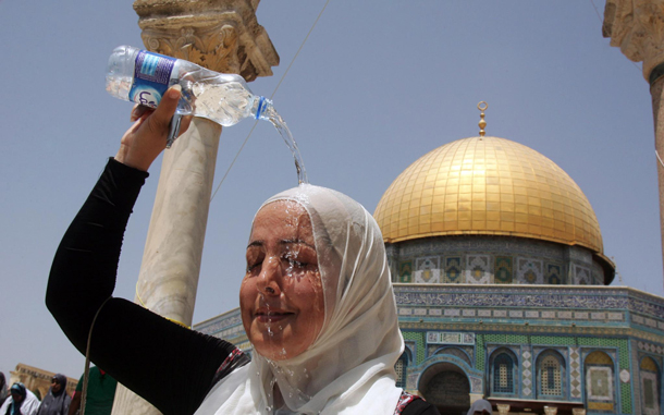 A woman pours a bottle of water over her head to cool down as she attends the second friday noon prayers in the Muslim holy month of Ramadan in front of the Dome of the Rock, nearby al-Aqsa Mosque, in Jerusalem. Temperatures during this year's Ramadan have been higher than normal and today in Jerusalem the temperature was to hit 39 degrees Celcius, some seven degrees higher than normal. (EPA)