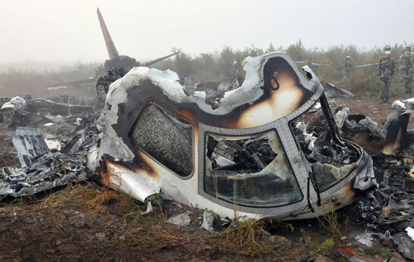Chinese paramilitary policemen stand guard near the Henan Airlines plane crashed on landing in Yichun in northeast China's Heilongjiang province. (AP)