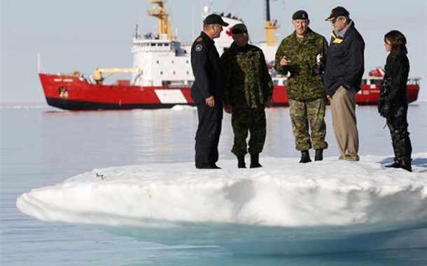 Canada's Prime Minister Stephen Harper (2nd R) talks with Chief of Defence Staff Walt Natynczyk (C) while standing on an iceberg in Allen Bay in Resolute, Nunavut. In the background is the Canadian Coast Guard icebreaker Henry Larsen. The operation is an annual joint Arctic exercise between the Canadian Maritime Command and Coast Guard. (REUTERS)