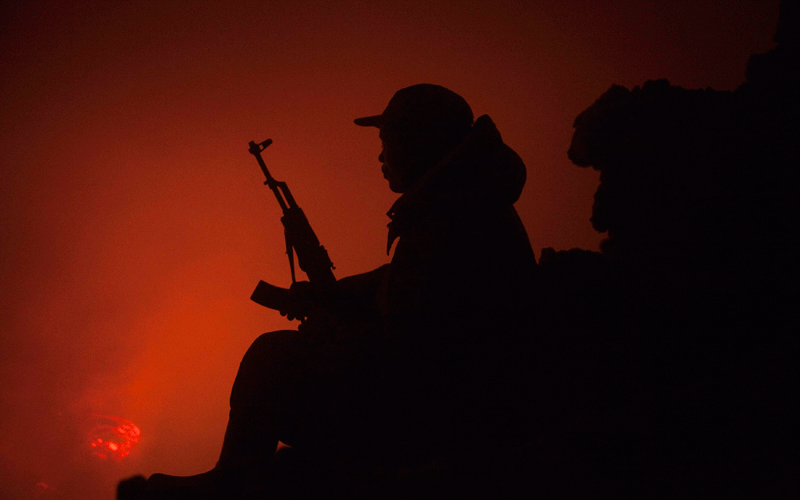 A Congolese soldier and guard for Virunga National Park looks down into a lava lake boiling in the crater of Nyiragongo volcano near Goma in eastern Congo. (REUTERS)