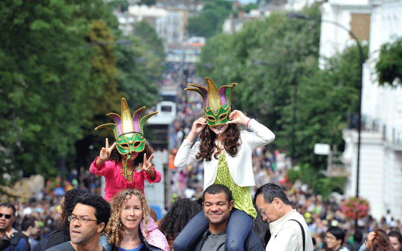 Spectators wearing masks join dancers and bands marching along the carnival route during the Notting Hill Carnival held in West London. (EPA)