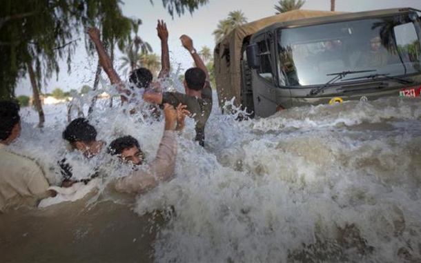 Residents being evacuated through flood waters dodge an army truck carrying relief supplies for flood victims in Pakistan's Muzaffargarh district in Punjab province. (REUTERS)