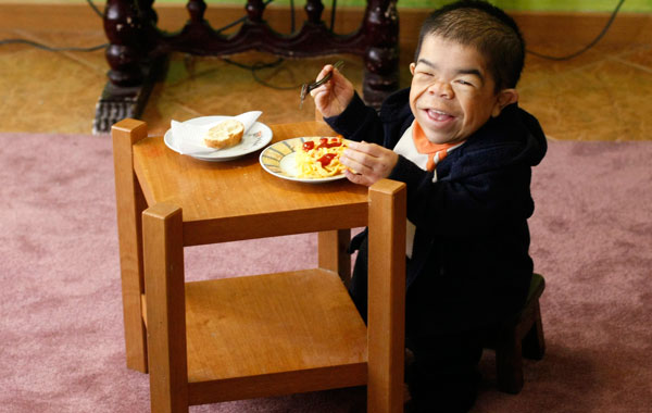 Edward Nino Hernandez eats lunch in his home in Bogota. (REUTERS)