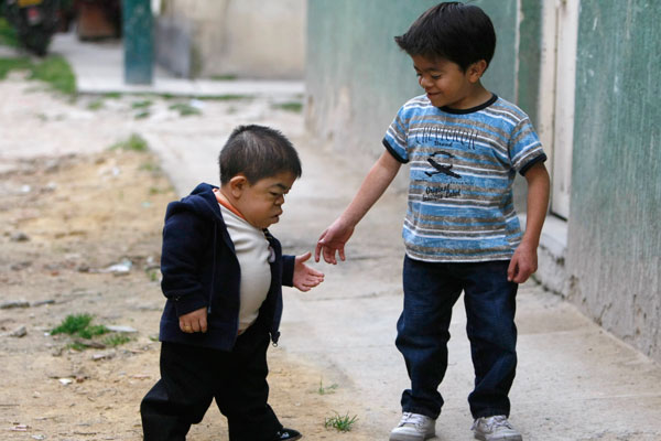 Edward Nino Hernandez (L) walks with his eleven-year-old brother outside their home in Bogota. (REUTERS)