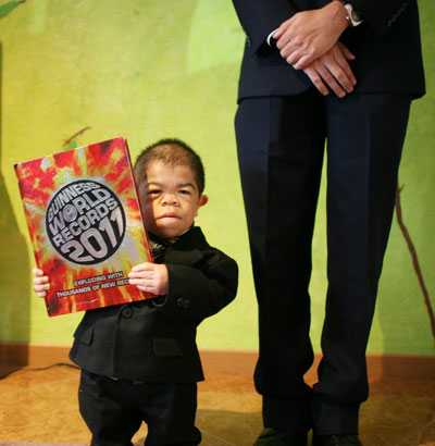 Edward Nino Hernandez, 24, poses for a portrait as he holds the Guinness World Record Book 2011 during an interview with Associated Press in Bogota, Colombia. (AP)