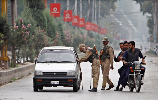 Indian paramilitary soldiers stop a vehicle during curfew in Srinagar, the summer capital of Indian. (EPA)