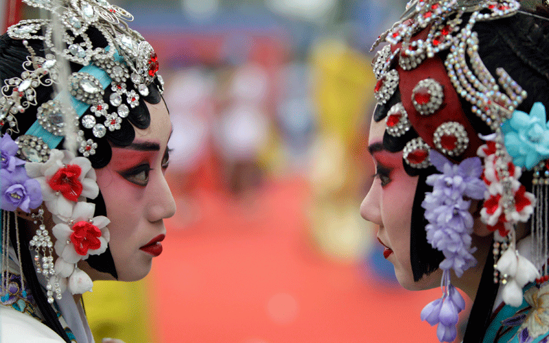 Chinese Peking Opera performers chat before the opening ceremony of 12th Beijing International Tourism Festival at Qianmen Commercial Street, in Beijing. (REUTERS)