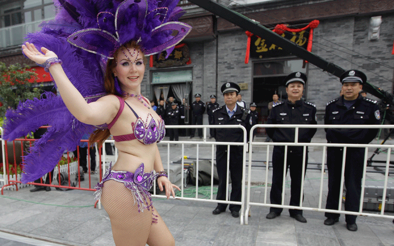 A performer from Finland dances past policemen during the opening ceremony of 12th Beijing International Tourism Festival along  Qianmen Commercial Street, in Beijing. (REUTERS)