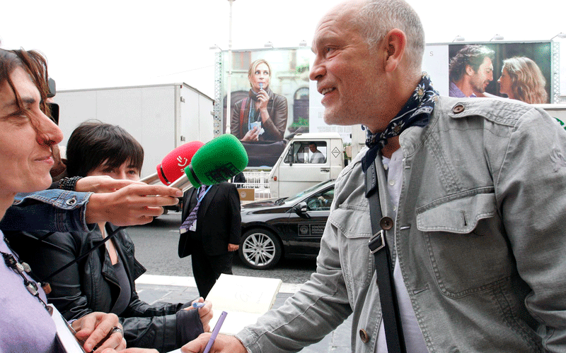 US actor, producer and film director John Malkovich (R) signs autographs upon his arrival several hours before the opening of the 58th San Sebastian International Film Festival in San Sebastian town, Basque Country, northern Spain. (EPA)