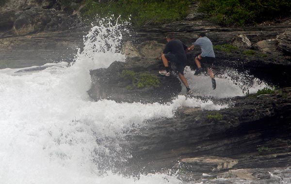 People try to escape waves crashing ashore at Spittal pond in Smith's Parish as Hurricane Igor approaches in Bermuda. (AP)