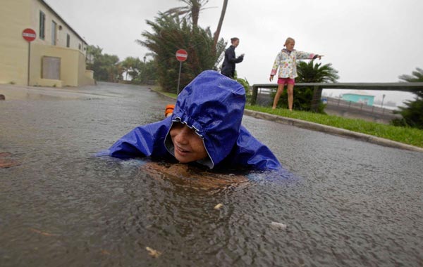 Seth Gibbons lies in standing water at Somerset Village as he and his family check out the effects of Hurricane Igor while the storm moves onto Bermuda. (AP)