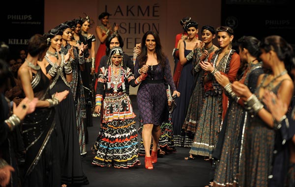 Models wearing creations by Indian designer Anita Dongre (C) applaud as she walks down the cat walk on the first day of Lakme Fashion Week (LFW) Winter/Festive 2010 in Mumbai. (AFP)