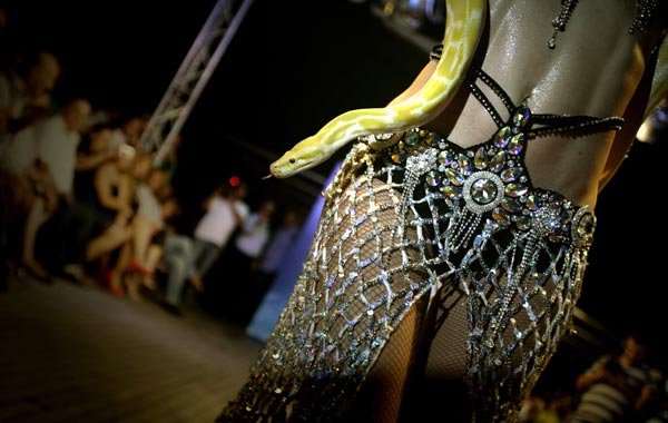 A dancer performs with a snake before the show by international Lebanese Fashion Designer Dany Atrach, from his 2010 Haute Couture collection, during a fashion show on board of a cruise boat off the shores of the town of Dbayeh, north of Beirut. (AFP)