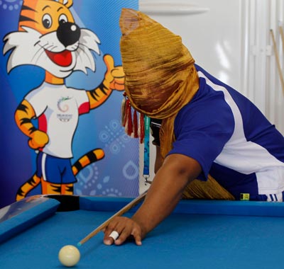 Niusila Opecoge of Samoa playfully puts a stole over his face as he plays pool at the Commonwealth Games Village in New Delhi, India. (AP)