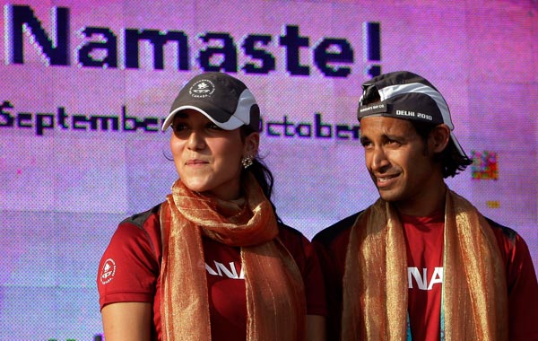 Canadian gymnast and winner of six Commonwealth Games gold medals Alexandra Orlando, left, and Canadian field hockey player Ben Periyar look on during their flag hoisting  ceremony in New Delhi, India. (AP)