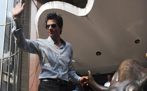 Bollywood star Shah Rukh Khan poses with the bronze statue of a bull outside the Bombay Stock Exchange (BSE) building after attending a listing ceremony for global movie distributor Eros International in Mumbai. (AFP)