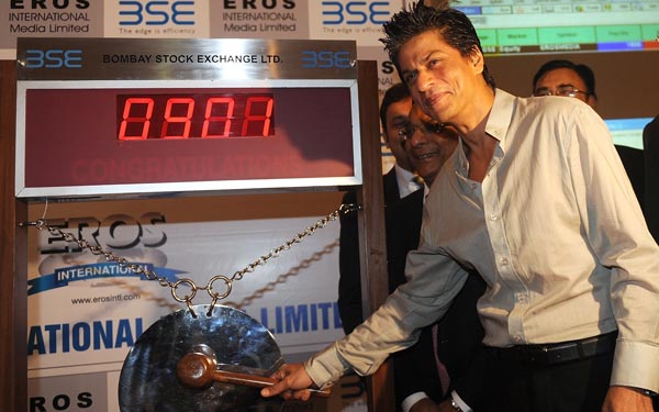 Bollywood star Shah Rukh Khan poses as he hammers a gong during the listing ceremony for Eros International on the Bombay Stock Exchange (BSE) in Mumbai. (AFP)