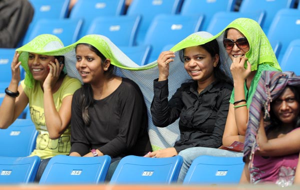 Spectators protect themselves from the sun during the Track and Field competition of the XIX Commonwealth games. (AFP)