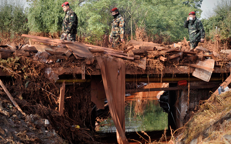 Hungarian soldiers wear protective masks, as they walk across a bridge in Devecser, Hungary. (AP)