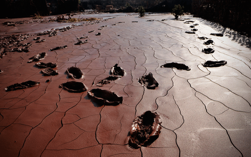 Footsteps pick their way through the toxic red sludge which covers a yard in Devecser, Hungary. (AP)