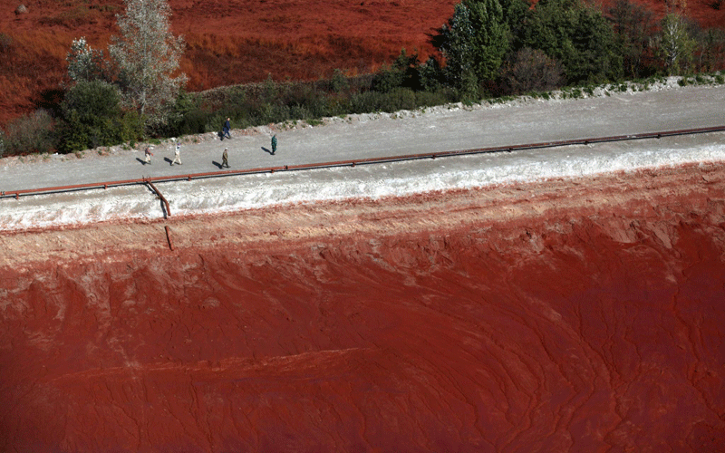 An aerial view of workers walking on a dike of a reservoir containing red mud of an alumina factory is seen near Ajka, 156 kms southwest of Budapest, Hungary. (EPA)