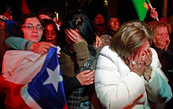 Residents cheer when the first rescuer reached the underground refuge of the miners trapped in the San Jose mine, while watching on a large screen in a public square in Copiapo. (REUTERS)