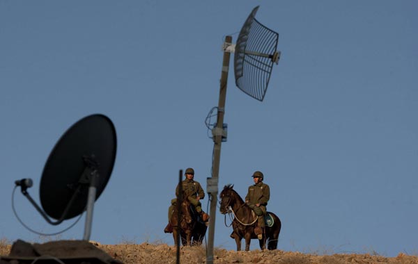 Two policemen stand guard next to the camp where journalists from all over the world cover the rescue operation of the 33 trapped miners, San Jose mine near Copiapo, Chile. (EPA)