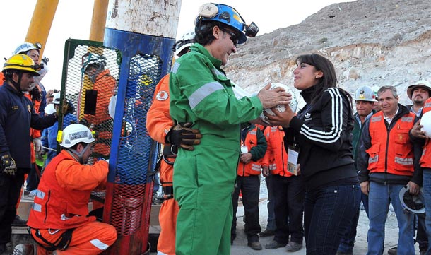 Chilean miner Franklin Lobos (L) holds a soccer ball next to his daughter Carolina Lobos (R) after being rescued from 700 meters underground in the capsule Fenix to the surface at the San Jose mine, Copiapo, Chile. The 33 miners were trapped since 05 August. (EPA)