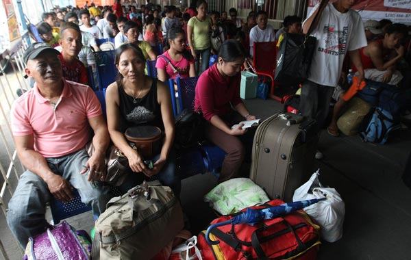 Filipino passengers wait at a pre-departure area following the cancellation of a provincial ferry ship travel due to weather forecasts on Typhoon Megi, at the harbor of Manila, Philippines. (EPA)