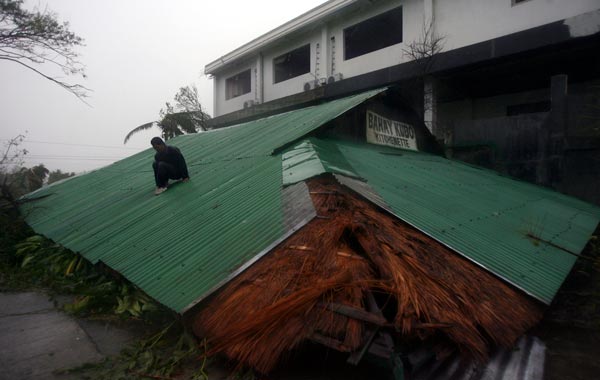 A man slides down the roof of a damaged hut as super typhoon Megi, known locally as Juan, hits Ilagan City, Isabela province, northern Philippines. (REUTERS)