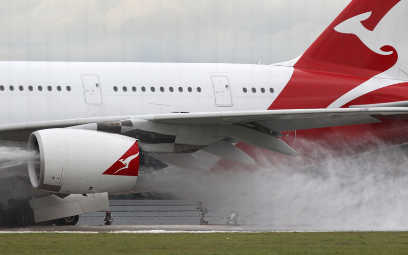 Firefighters surround a Qantas passenger plane which made an emergency landing in Singapore's Changi International Airport  after having engine problems on Thursday Nov. 4, 2010 in Singapore. (AP)