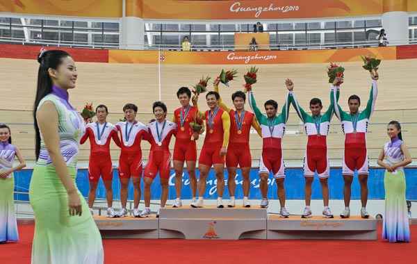 Men's team sprint cyclists from left, Japan, silver, China, gold and Iran bronze celebrate on the podium following their medal ceremony at the 16th Asian Games in Guangzhou, China. (AP)