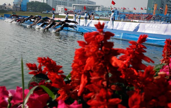 Competitors dive in to start the swim leg of the men's triathlon during the 16th Asian Games in Guangzhou, China. (AP)