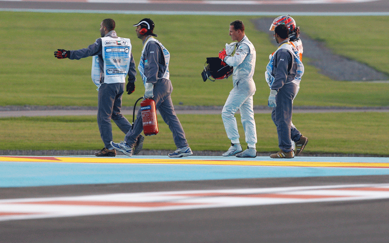 Mercedes Grand Prix driver Michael Schumacher of Germany walks off the track after crashing with Force India driver Vitantonio Liuzzi of Italy during the Emirates Formula One Grand Prix at the Yas Marina racetrack, in Abu Dhabi, United Arab Emirates. (AP)