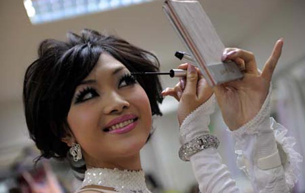 Japan's Ami Takeuchi (first runner-up) applies make-up backstage ahead of the Miss International Queen 2010 beauty pageant. (AFP)