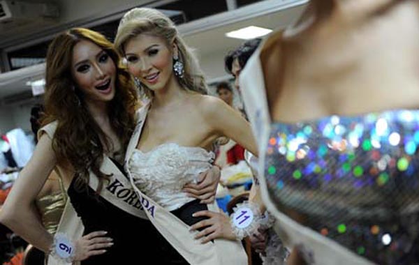 South Korea's Mini (L) and Canada's Jenna Talackova (C) pose for pictures backstage ahead of the Miss International Queen 2010 beauty pageant. (AFP)