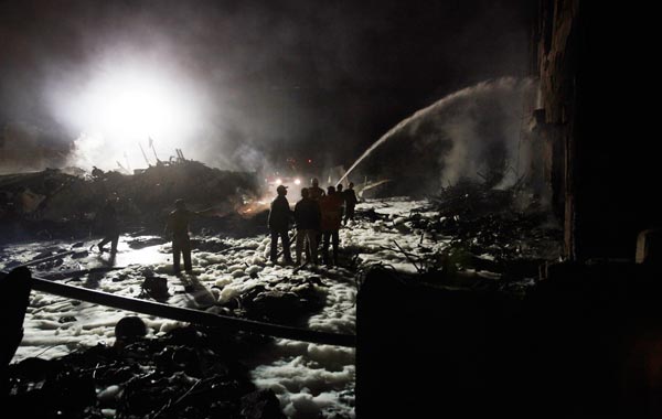 Firefighters douse the burning wreakage of an airplane which crashed in Karachi November 28, 2010. A plane carrying eight people crashed early on Sunday in a residential area of Karachi, Pakistan's biggest city, setting buildings on fire.  (REUTERS)