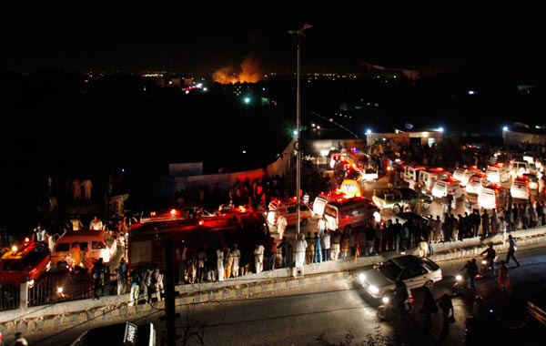 Ambulances line up outside the gates to a Naval residential neighborhood where an airplane crashed in Karachi. (REUTERS)
