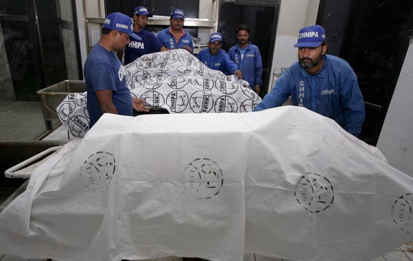 Pakistani rescue workers cover the dead bodies of victims of a plane crash, at the morgue of a local hospital in Karachi, Pakistan. (AP)