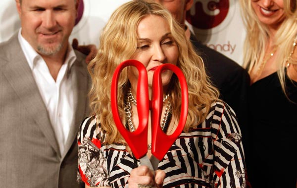 U.S. singer Madonna, front, holds up scissors to cut the ribbon as she poses for pictures during the opening of Hard Candy Fitness, her new gym in Mexico City. (AP)