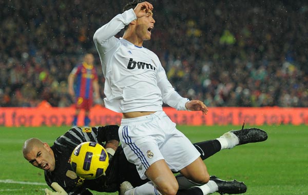 Cristiano Ronaldo (R) of Real Madrid is fouled in the penalty aeria by goalkeeper Victor Valdes of Barcelona during the la liga match between Barcelona and Real Madrid at the Camp Nou stadium in Barcelona, Spain. (GETTY)