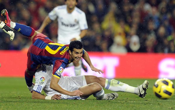 Barcelona's forward Pedro Rodriguez (L) vies with Real Madrid's Portuguese defender Pepe (bottom) during the Spanish league "clasico" football match FC Barcelona vs Real Madrid at Camp Nou stadium in Barcelona. Barcelona won 5-0. (AFP)